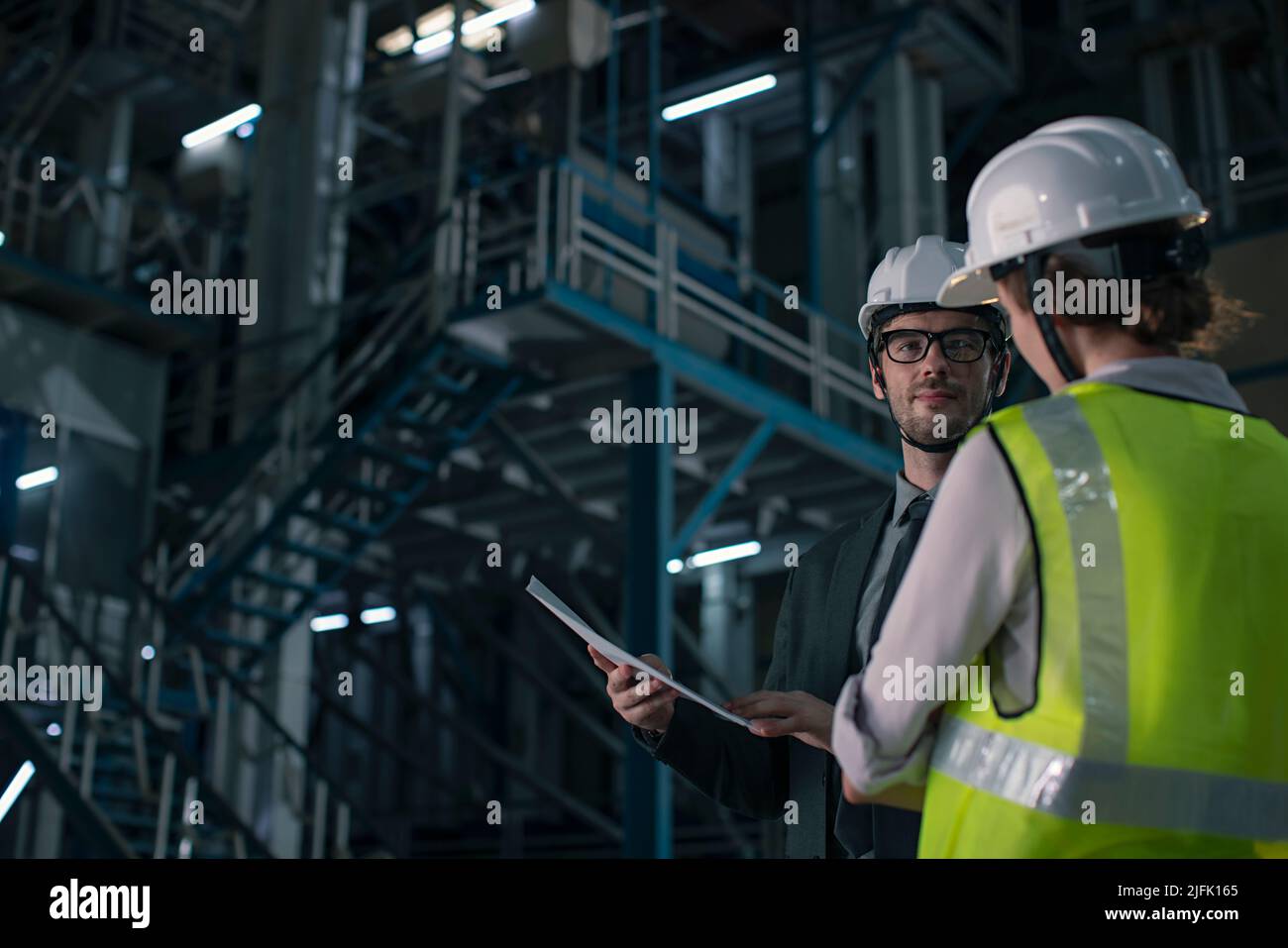 Businessman in meeting with a young woman in the factory Stock Photo