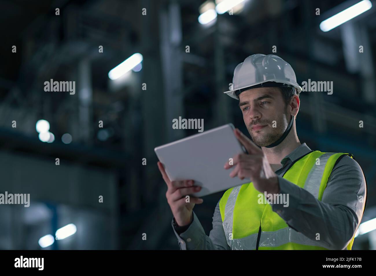 Mid adult man working on the digital tablet in the factory Stock Photo