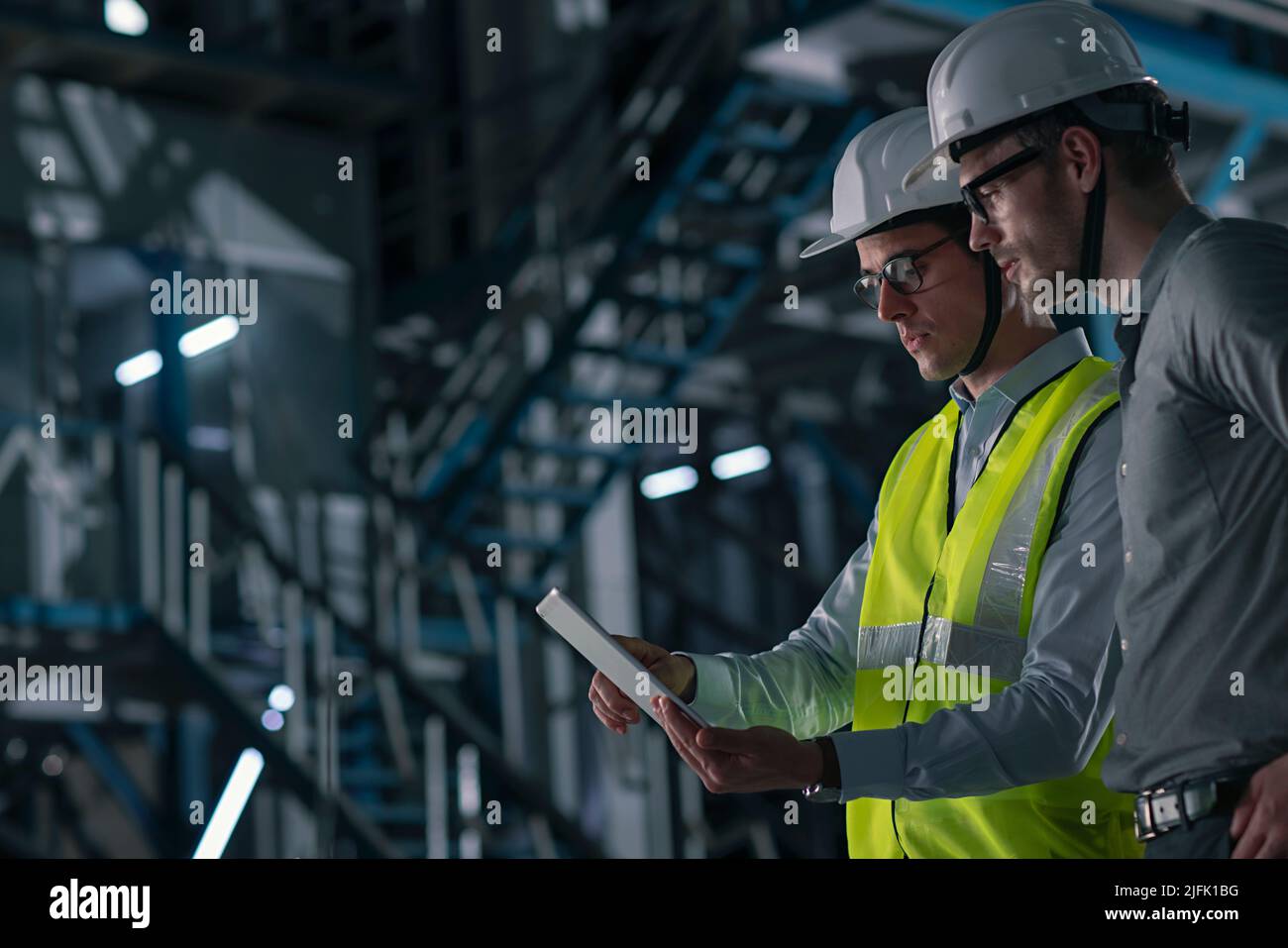 Two mid adult man working on the digital tablet in the factory Stock Photo