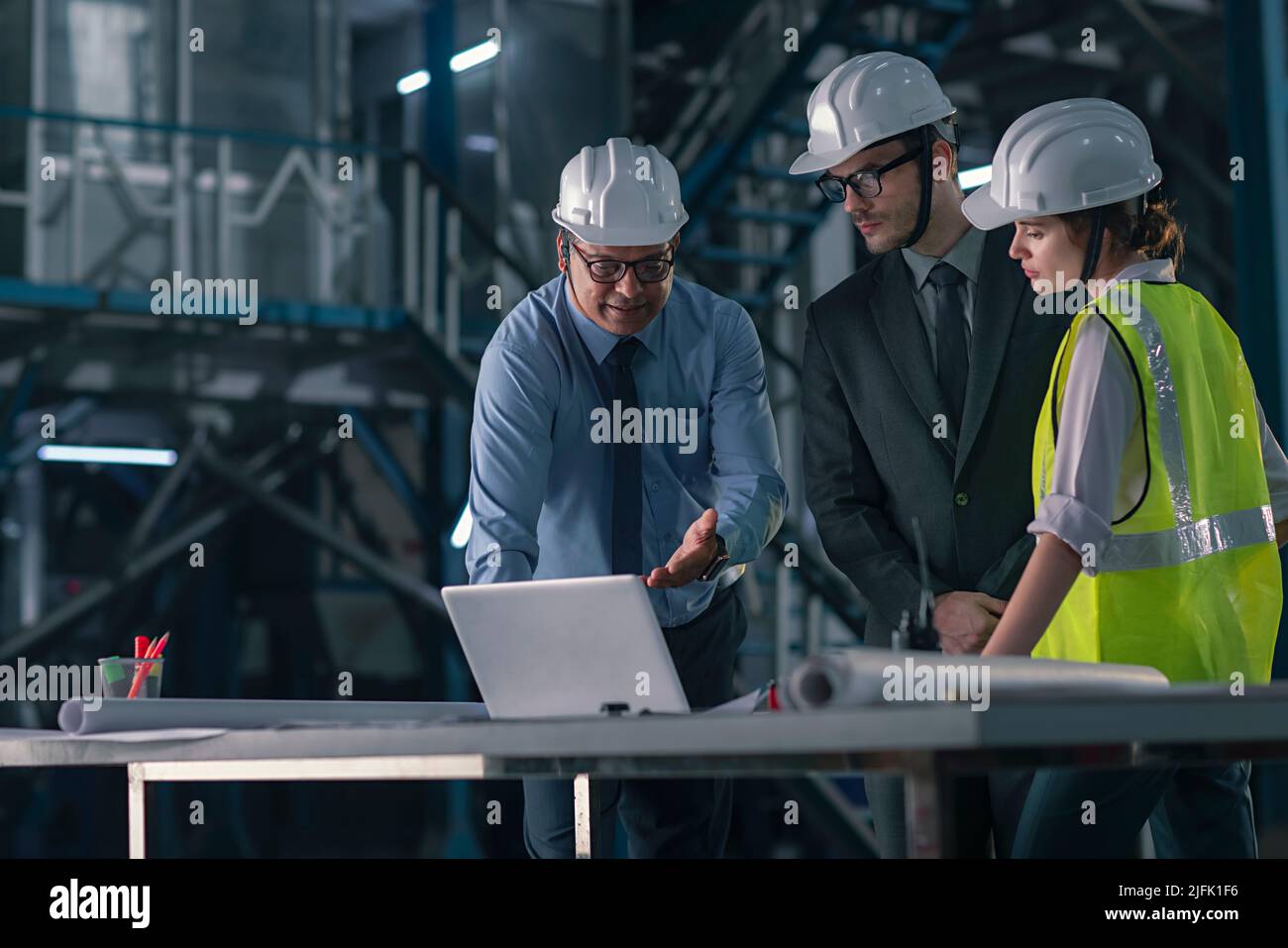 Businessman working on laptop with his employee in the factory Stock Photo
