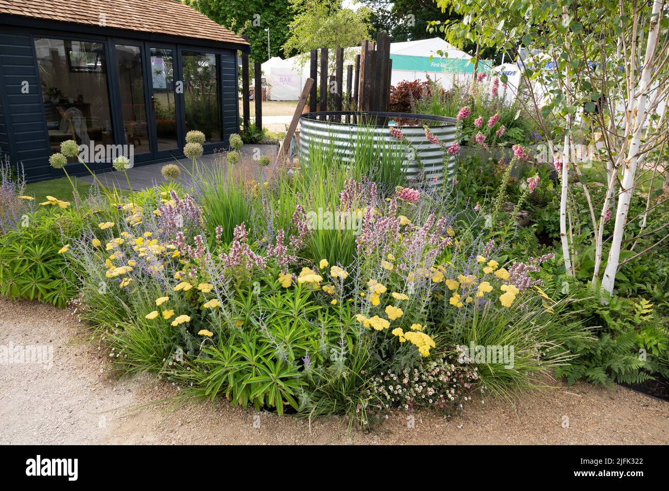 Hampton Court Palace, Surrey, UK. 4 July 2022. RHS Hampton Court Palace Garden Festival press day for the worlds largest flower show, running till 9 July 2022. Image: Feature garden: The Vitamin G Garden designed by Alan Williams with Jo Whiley is inspired by the evidence-based research that was published in April 2021 by RHS  scientists Professor Alistair Griffiths and Dr Lauriane Chalmin-Pui that proves how gardening benefits our mental, physical and social wellbeing. Credit: Malcolm Park/Alamy Live News Stock Photo