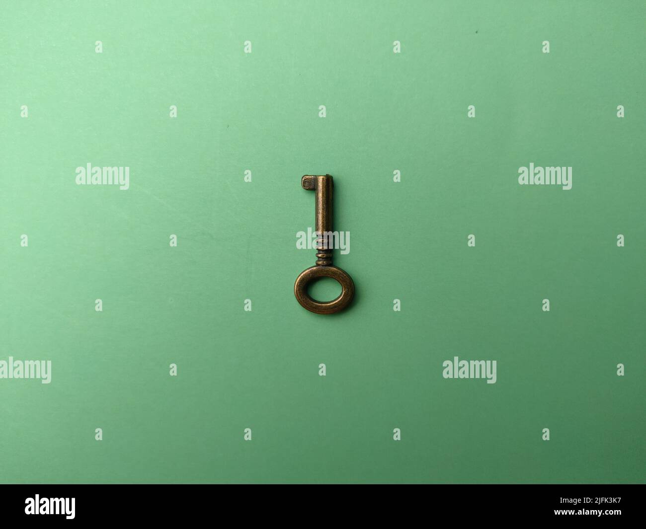 A bronze vintage key on soft green paper background Stock Photo - Alamy