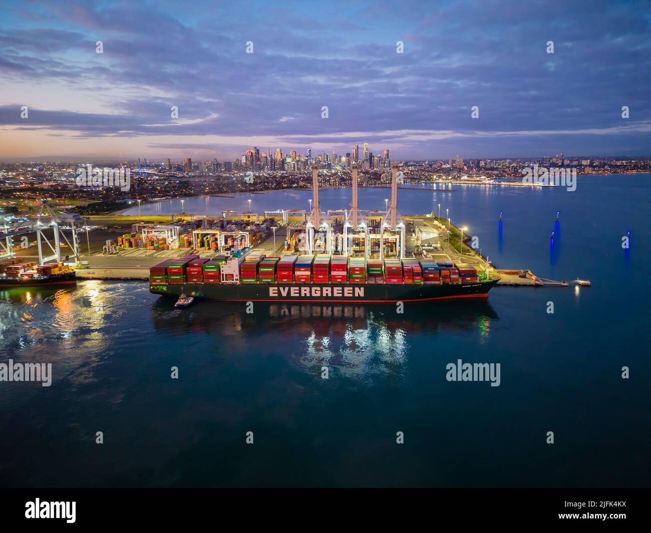 Melbourne, Australia - Jun 29, 2022: Aerial view of container ship arriving at Port of Melbourne at sunset Stock Photo
