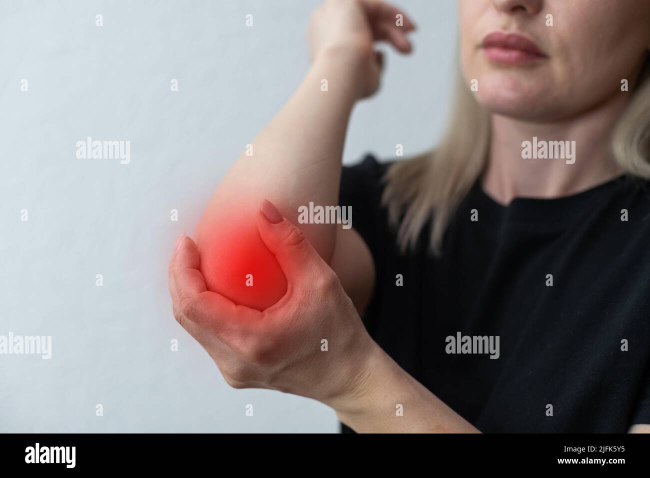 women elbow pain, holding hand to spot of elbow pain. Arm pain and