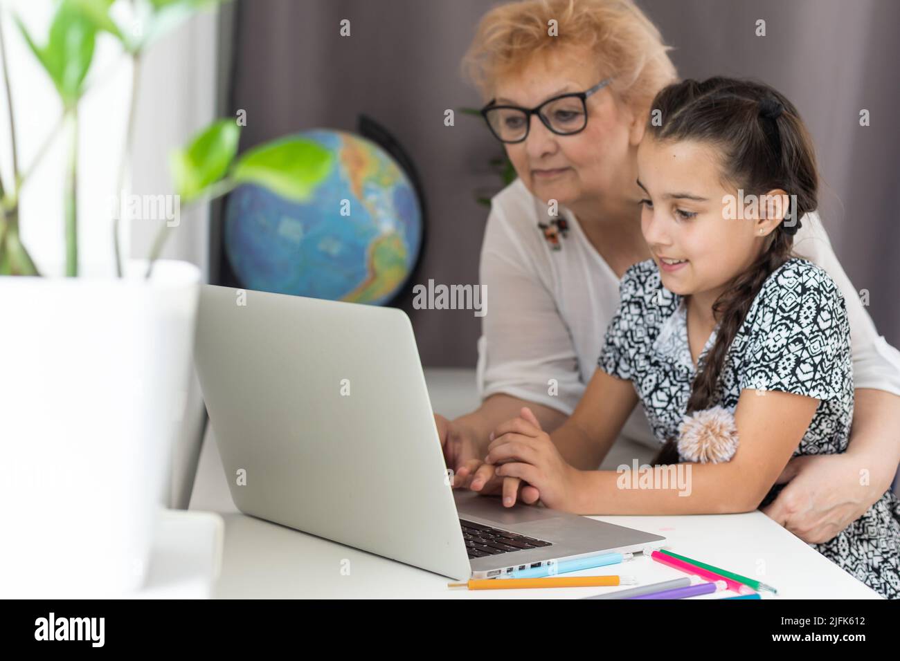 Grandmother and granddaughter using tablet and laptop Stock Photo - Alamy