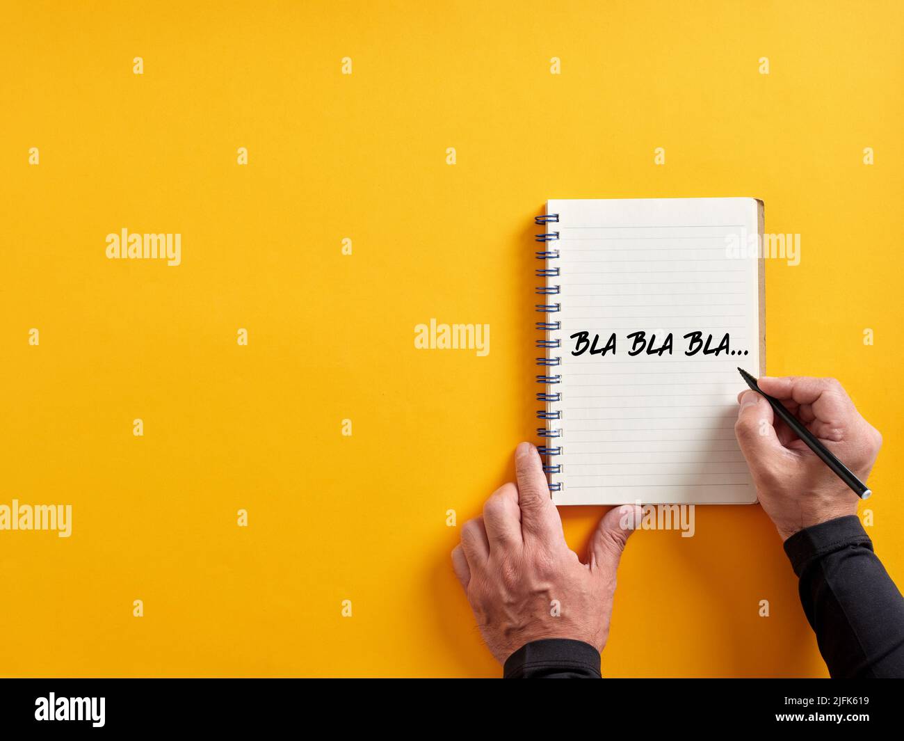 Male hand writing bla bla bla on a notepad. Business concept for talking too much with false information or gossip nonsense speaking. Stock Photo