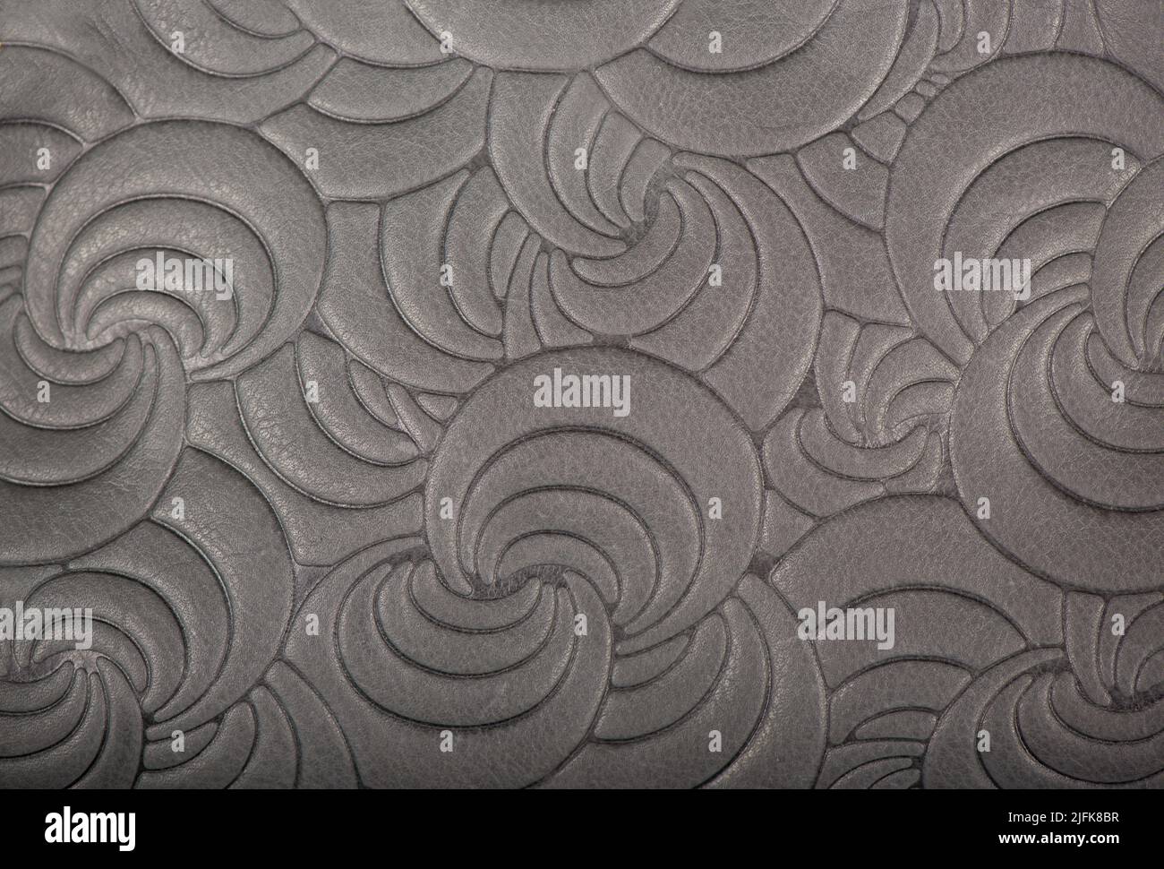 Texture of gray genuine leather with embossed floral trend pattern