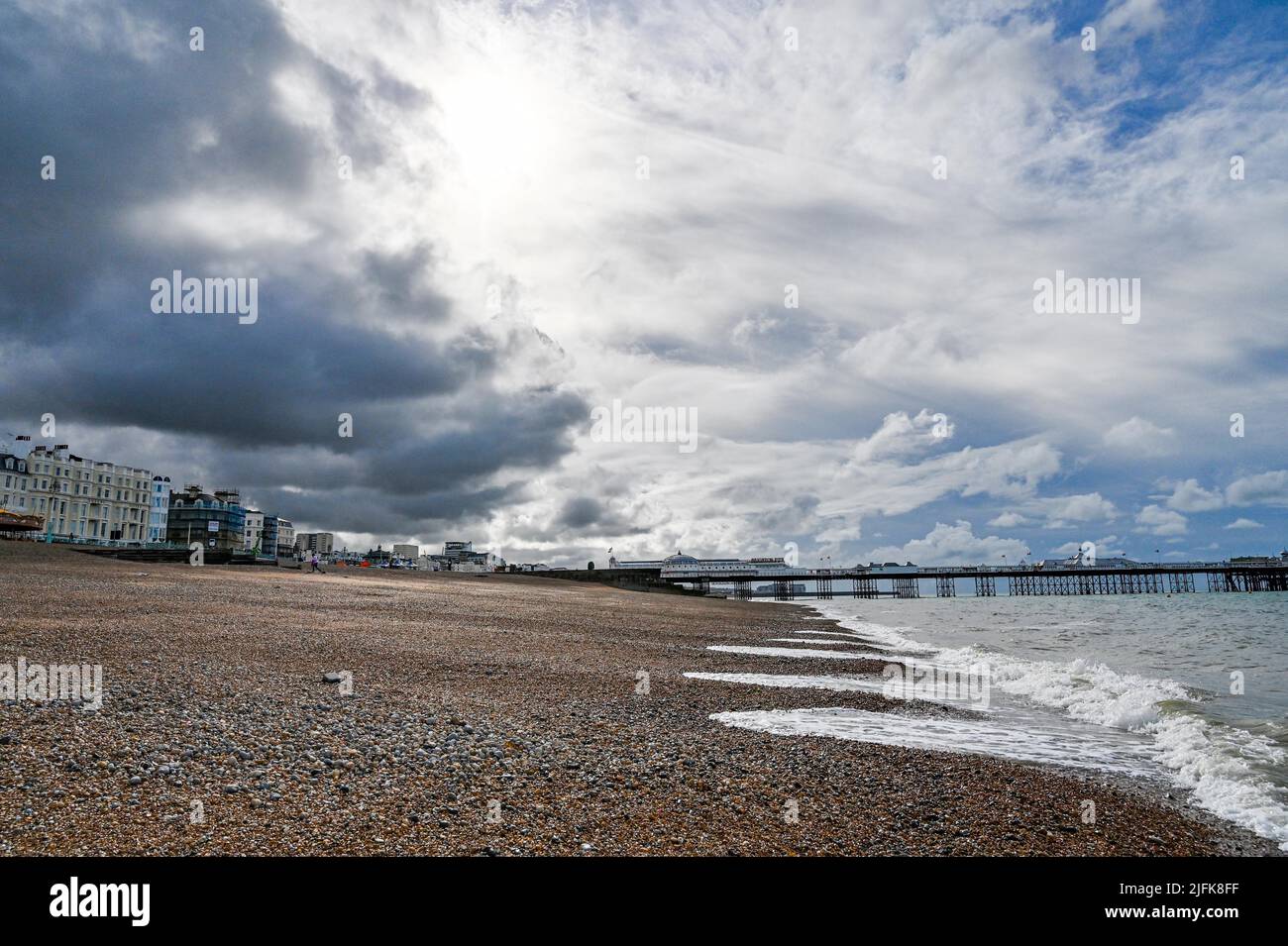 Brighton , Sussex , England  UK  - Dark clouds over Brighton seafront and beach with sun trying to break through Stock Photo