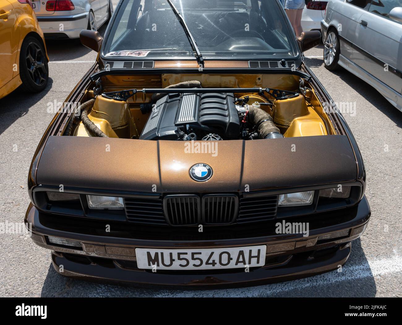 beautiful brown BMW E30 with square headlights and an open hood. stance