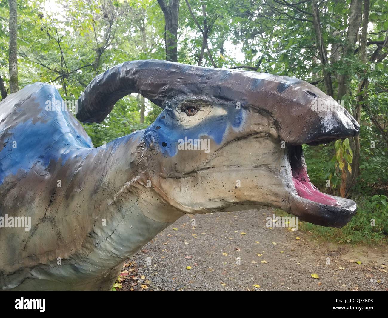 a blue and grey dinosaur in the forest or woods Stock Photo Alamy