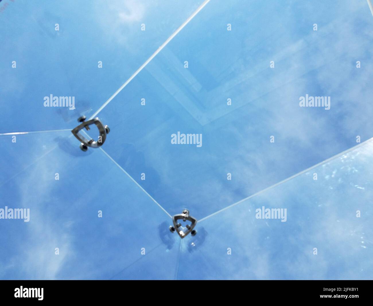 view of blue sky and clouds from clear ceiling from inside transparent