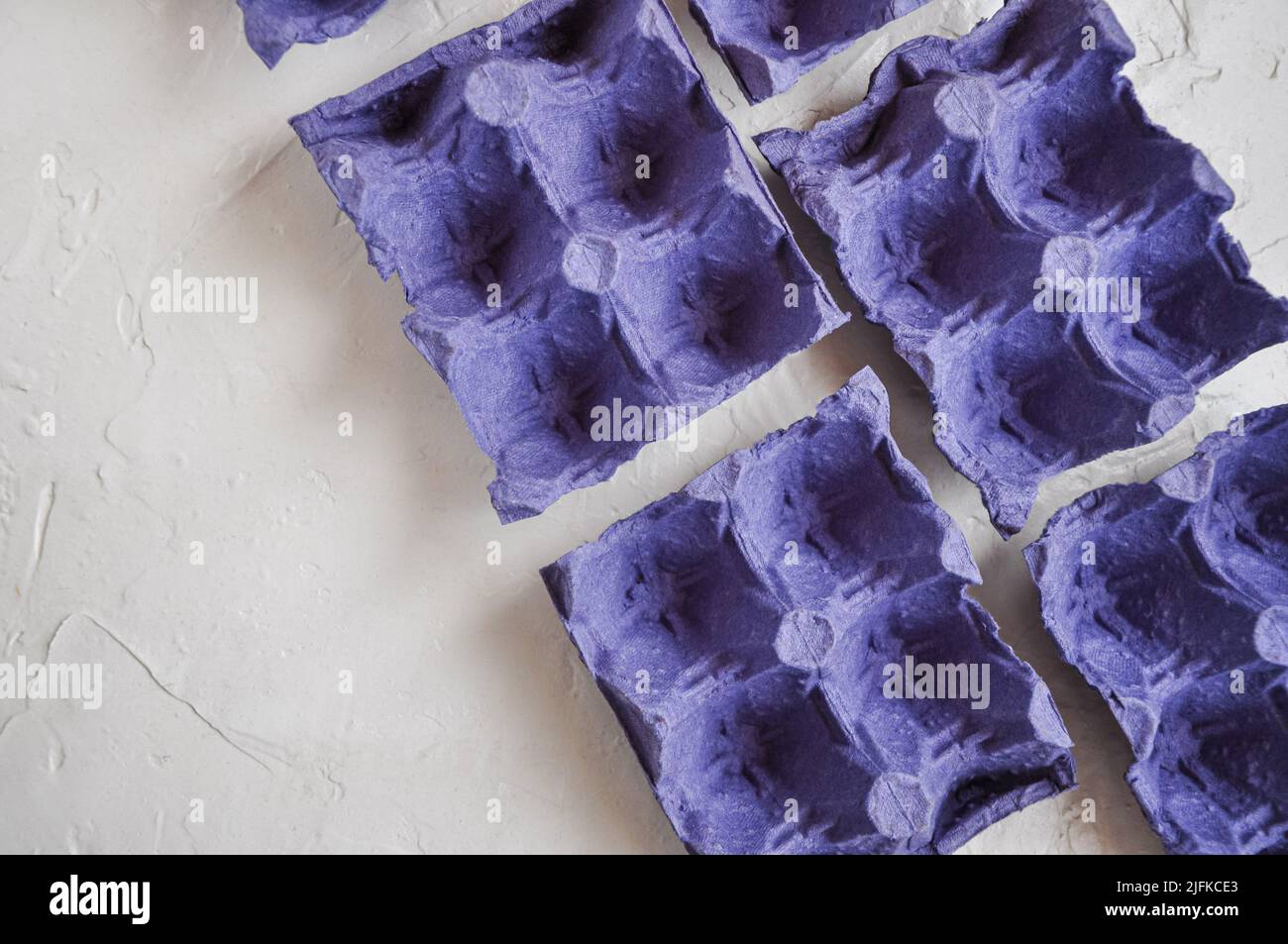 Top view of empty egg cartons, of bluepurple colors, to recycle, on
