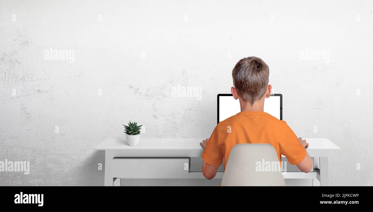 Boy typing on a laptop computer. The concept of sending an email or corresponding with friends. Protection of privacy of minors Stock Photo