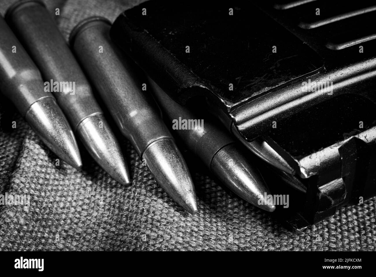 Ak-47 (7,62x39mm) ammunition being loaded to magazine, military canvas background, monochrome photo Stock Photo