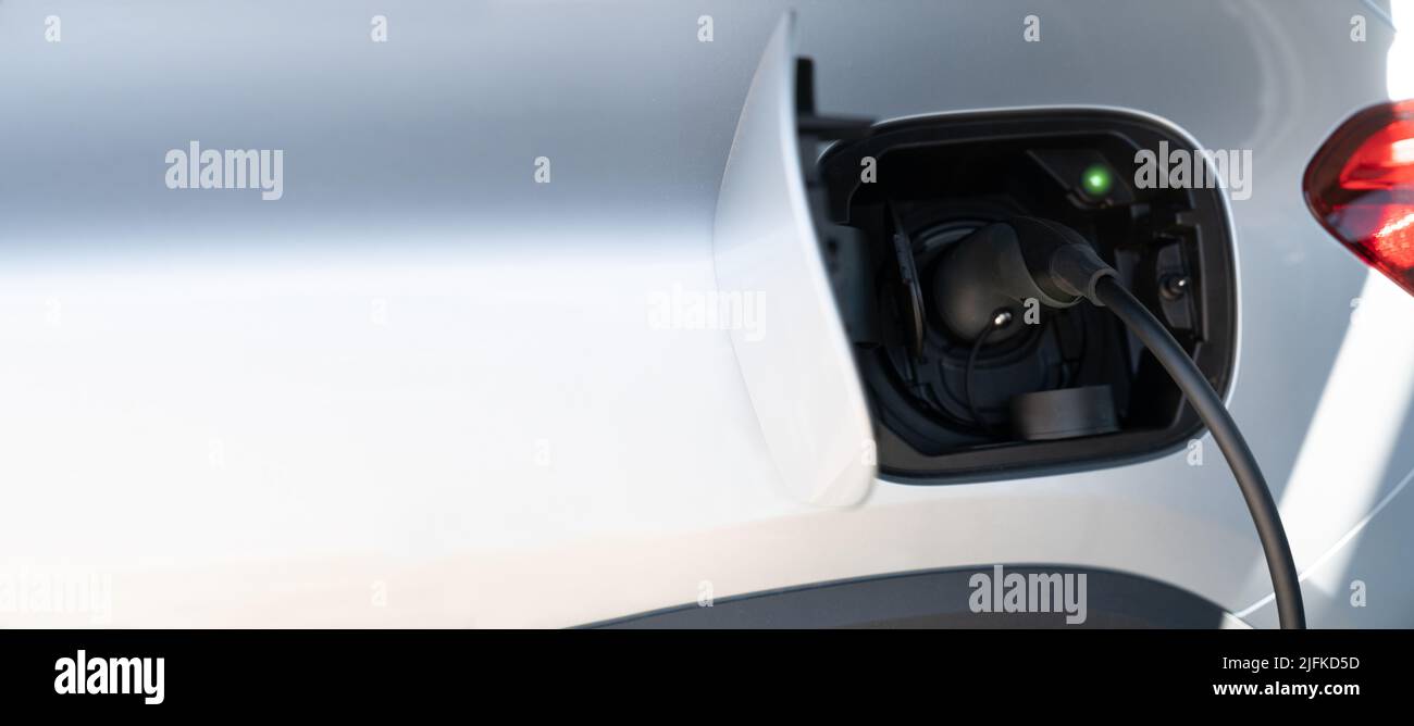 Close up of electric car with a connected charging cable Stock Photo