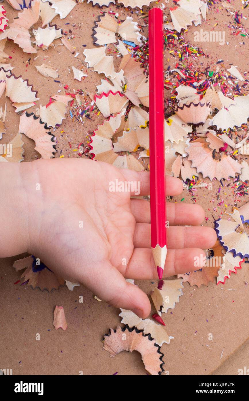 Red Color Pencil over pencil shavings. Stock Photo