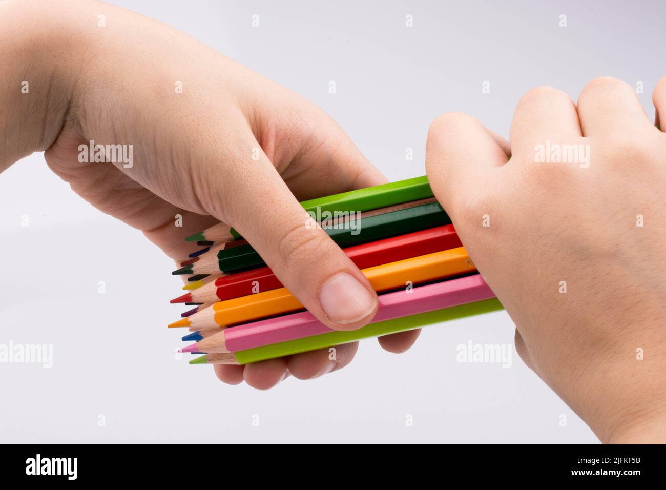 Hand holdin color pencils on a white background. Stock Photo