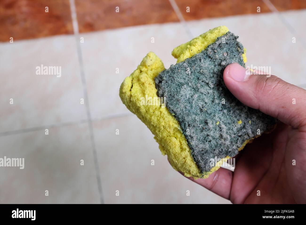 Selective focus of torn, worn out and dirty dishwashing kitchen sponge