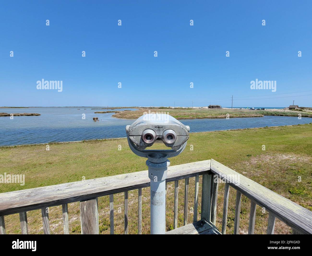 viewfinder or binoculars with water and green grass and blue sky outdoor. Stock Photo