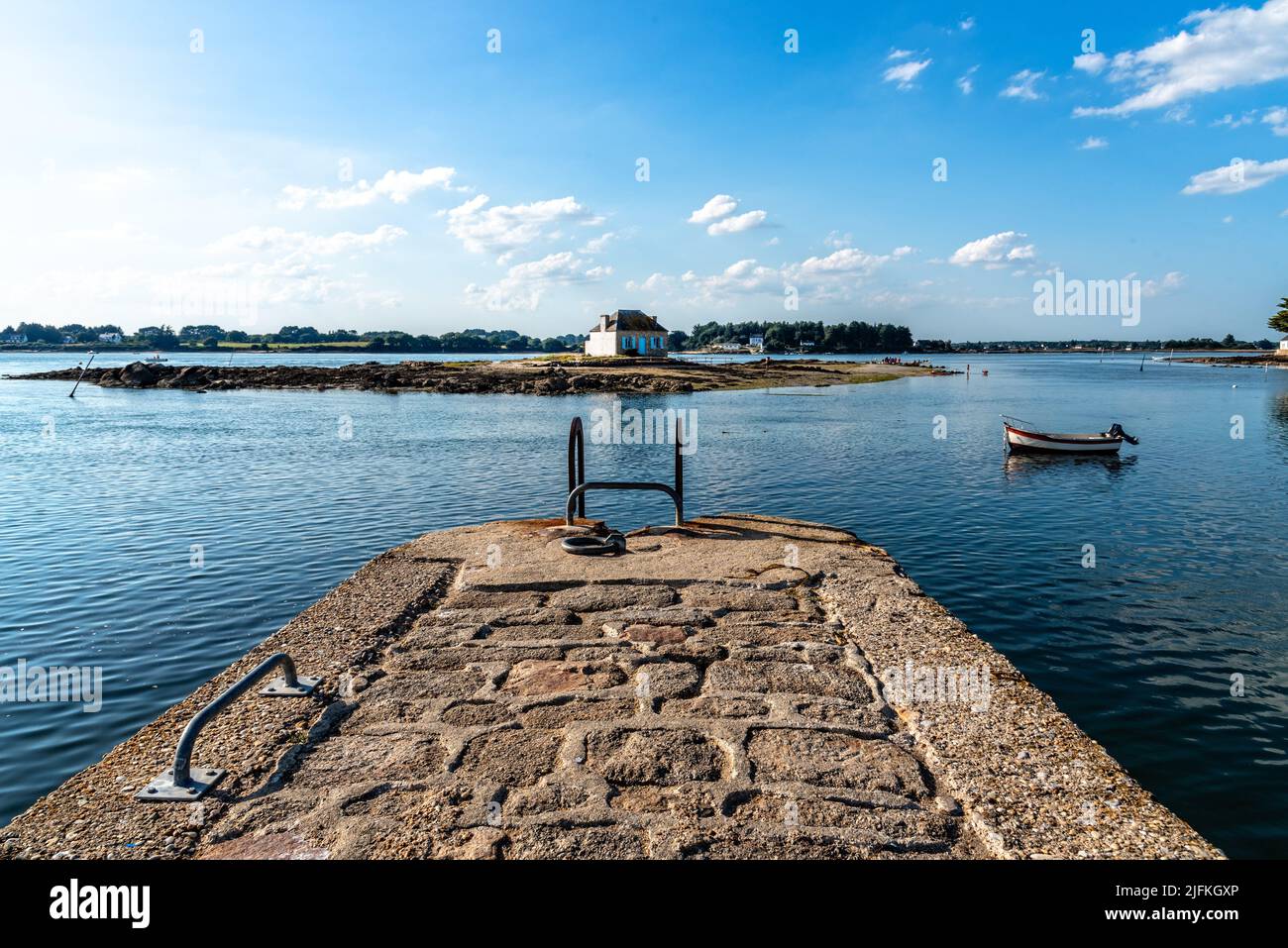 Small island with a cottage in the Etel River, Ile de Saint-Cado, Brittany, France. House in water with fishing boats. Stock Photo