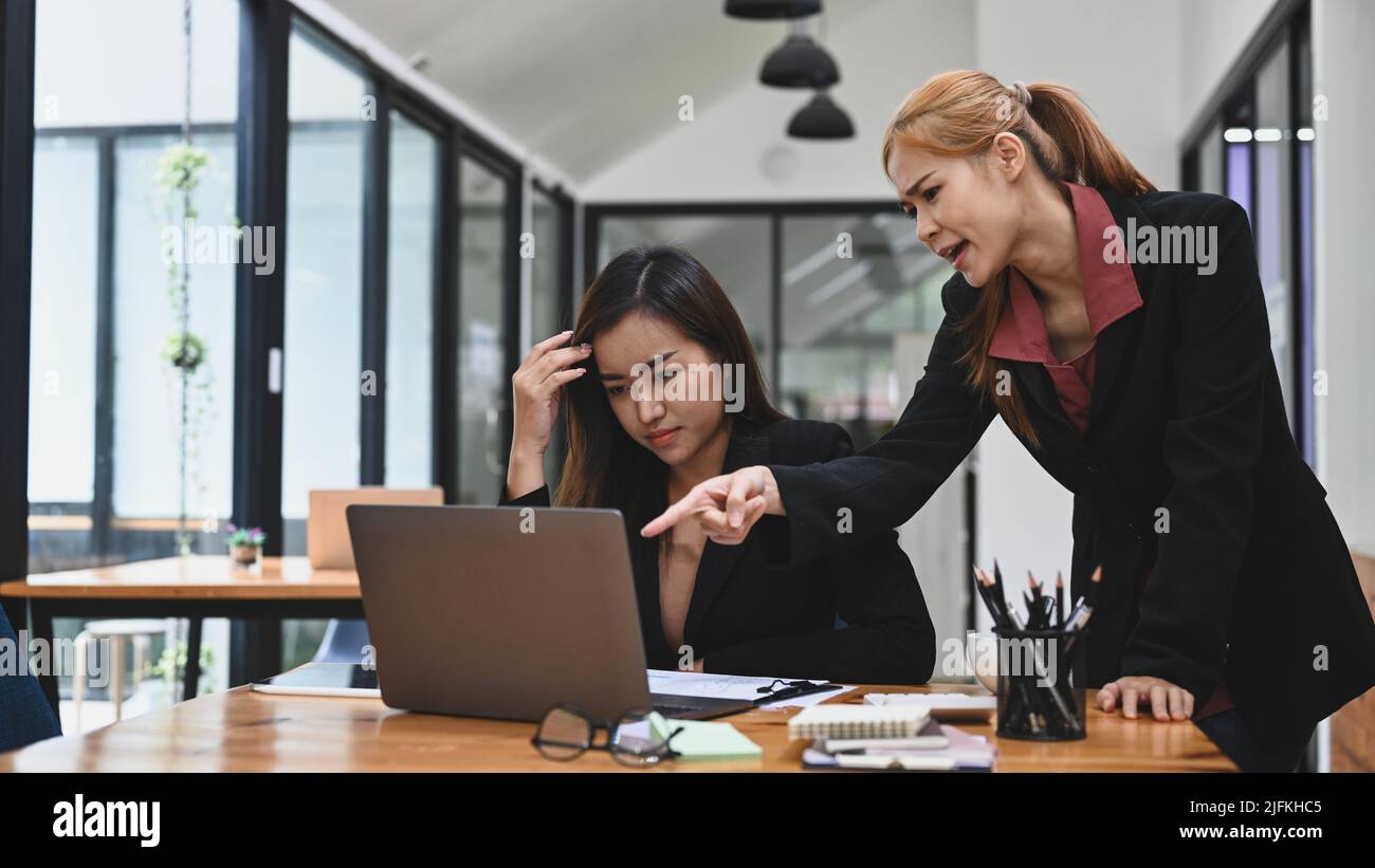 Furious manager scolding young frustrated young employee with bad work