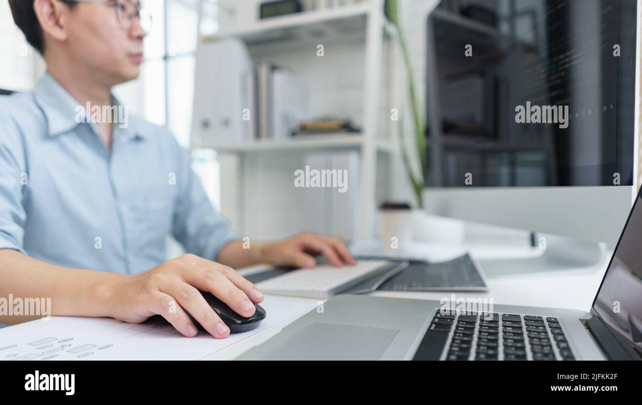 Software development concept, Male programmer typing data code on laptop to develop app and website. Stock Photo