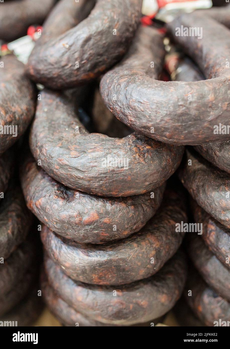 Black sausage or black iberian morcilla pile displayed at street market stall. Closeup. Stock Photo