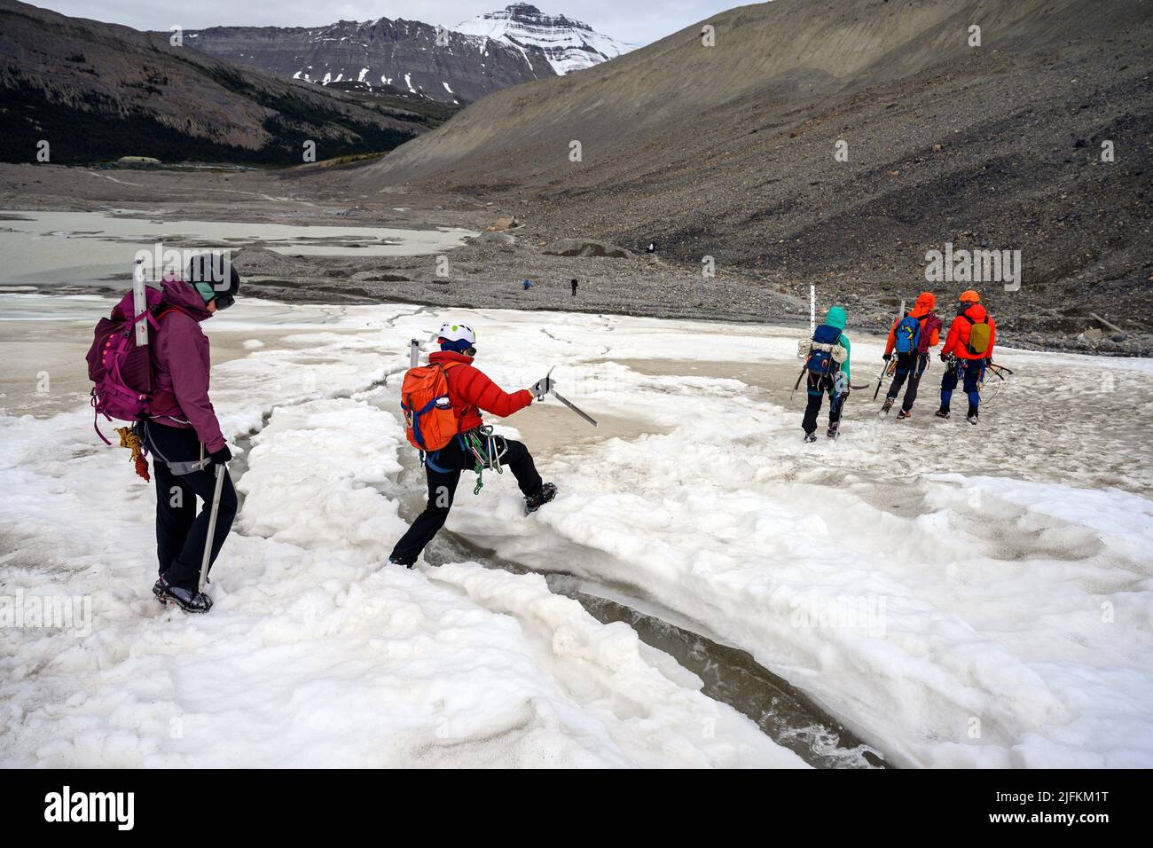 Mountaineers, ice trekkers, ice climbers, hikers and tourist people are exploring the glacier by walking on it, at Columbia Icefield, Japser National Stock Photo
