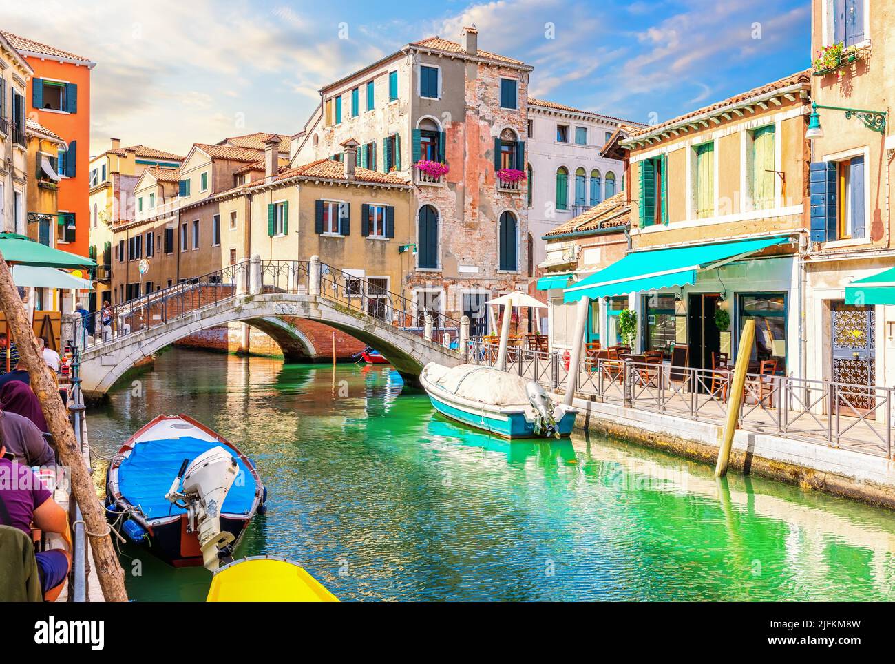 Medieval Bridge, Cafe and colorful houses in the Grand Canal, Venice, Italy. Stock Photo