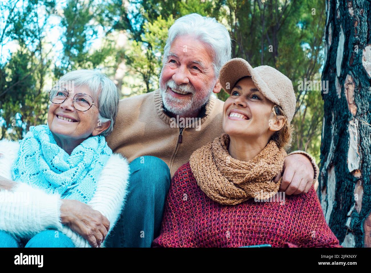 Caucasian family portrait smile and hug with nature trees forest background. Adult and mature retired people enjoying leisure activity outdoors Stock Photo