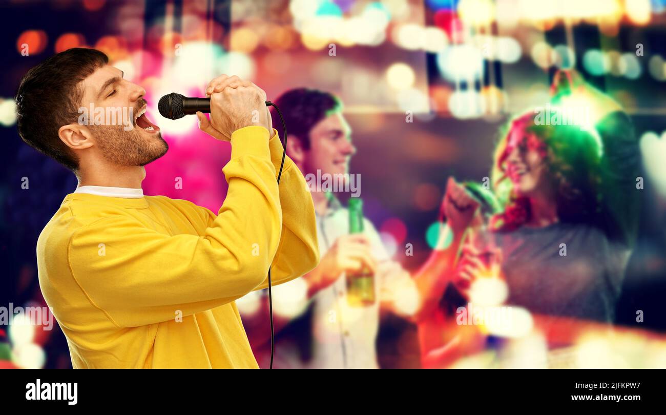 man with microphone singing at night club Stock Photo