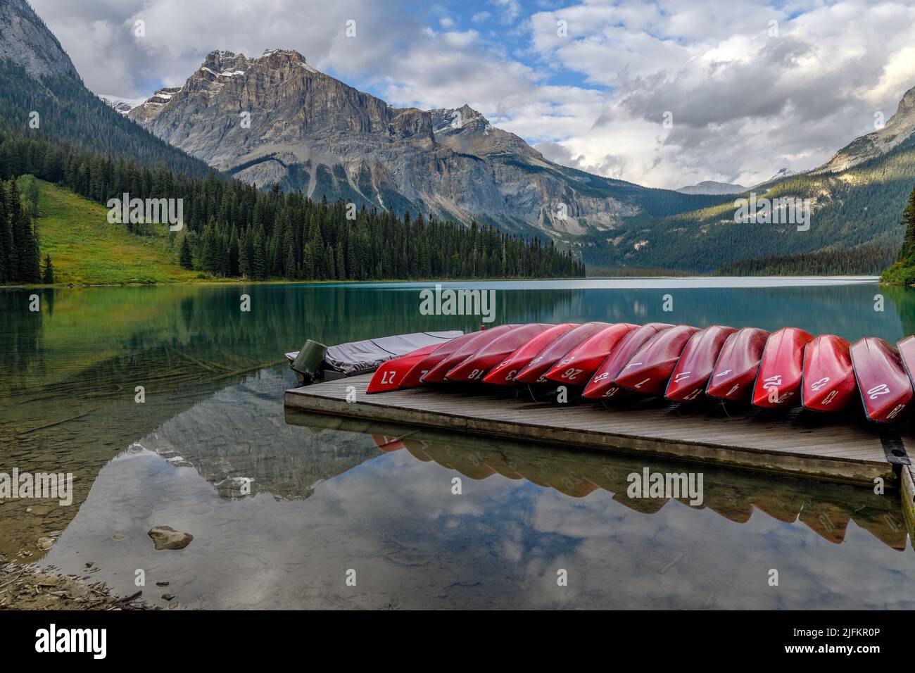 Reflecting red kayaks on deck at the Emerald Lake in Yoho National Park, British Columbia, Canada. Stock Photo