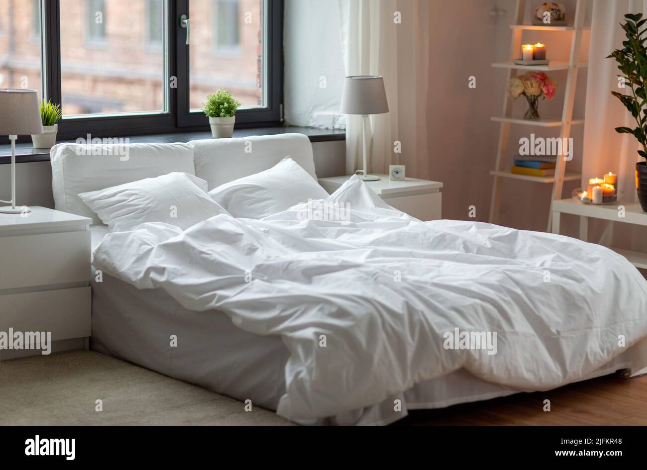 cozy bedroom with white linen on bed Stock Photo - Alamy