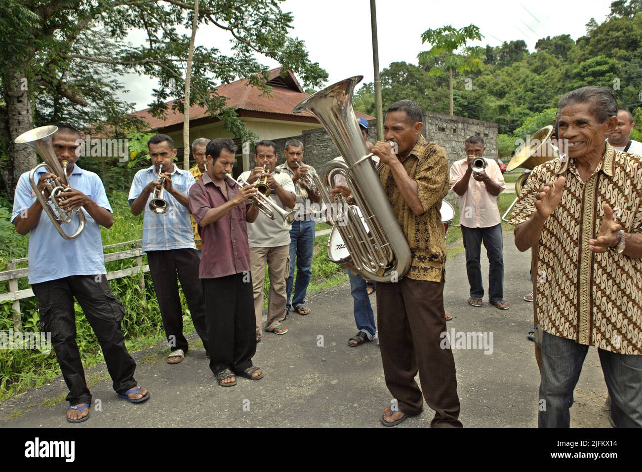 Villagers playing brass instruments during a rural orchestra performance to welcome tourists in Rumahkay village, Amalatu, West Seram, Maluku, Indonesia. Stock Photo
