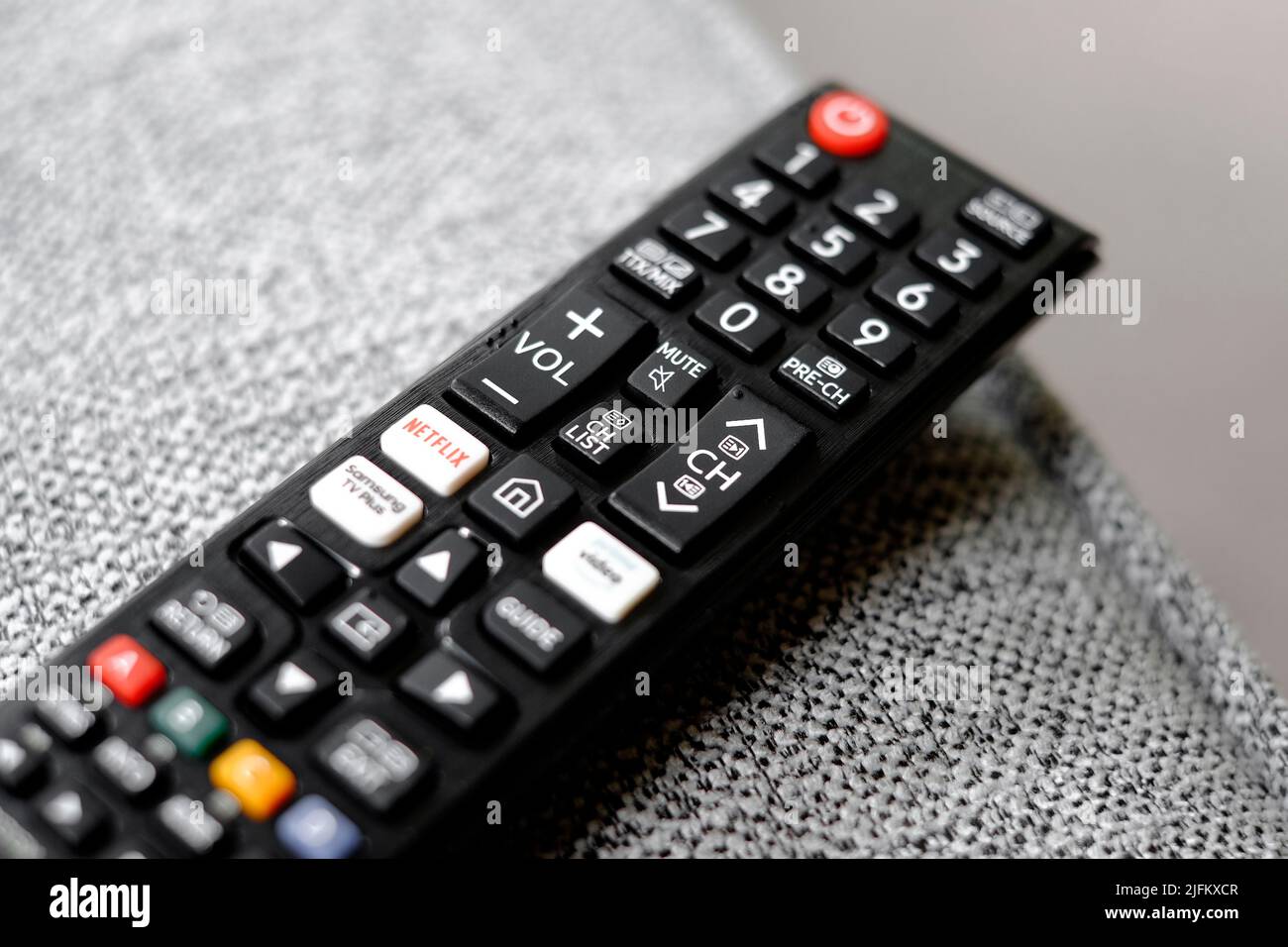 television remote control on fabric sofa Stock Photo