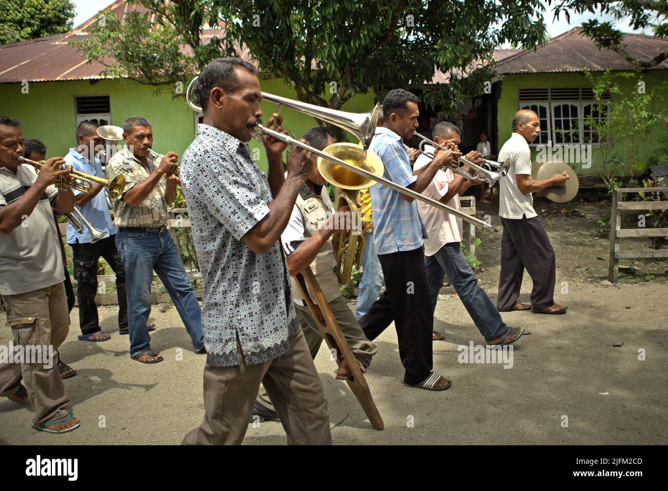 Villagers playing brass instruments during a rural orchestra performance to welcome tourists in Rumahkay village, Amalatu, West Seram, Maluku, Indonesia. Stock Photo