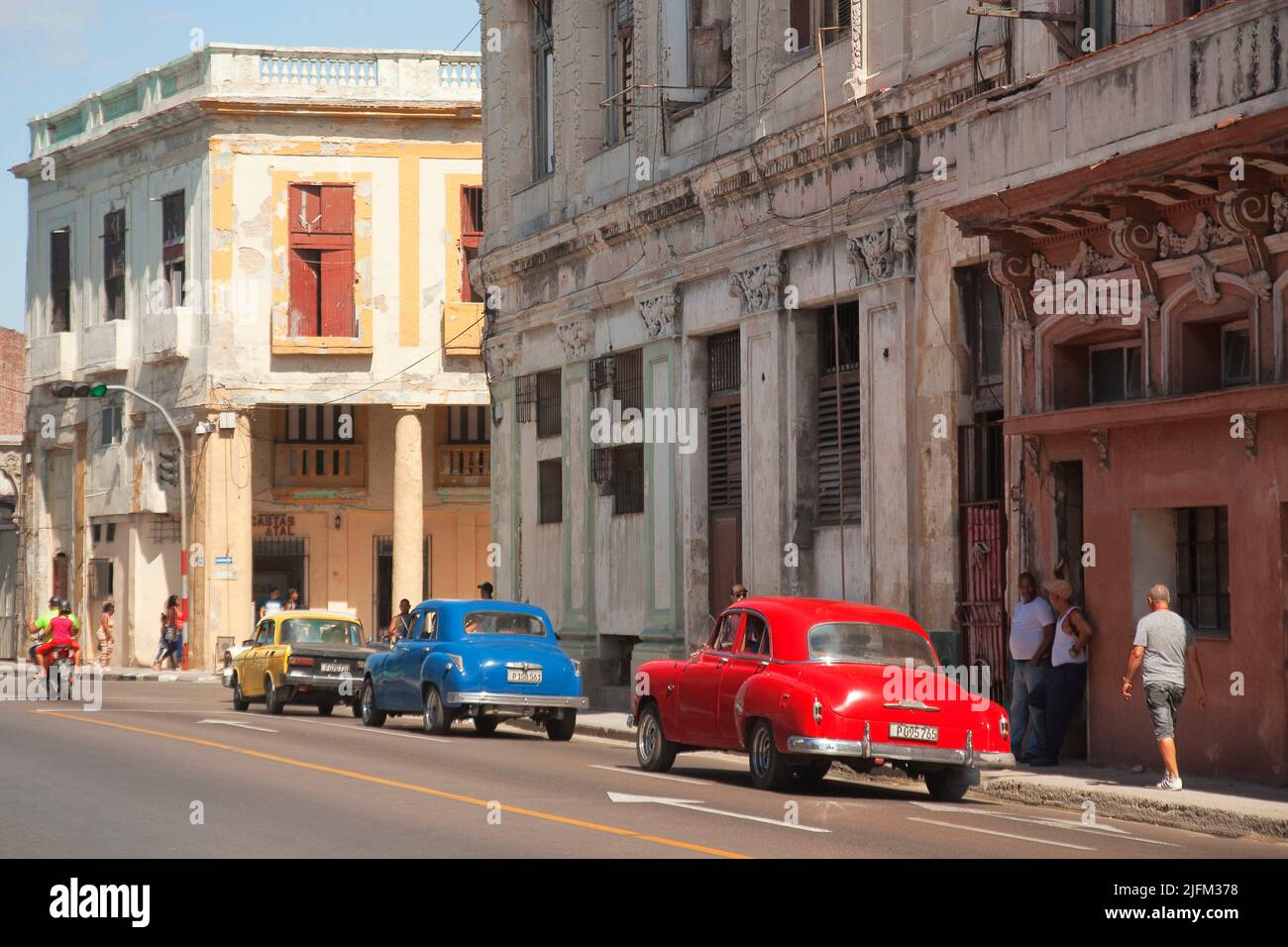 Old American cars used as taxi in front of the colonial buildings in