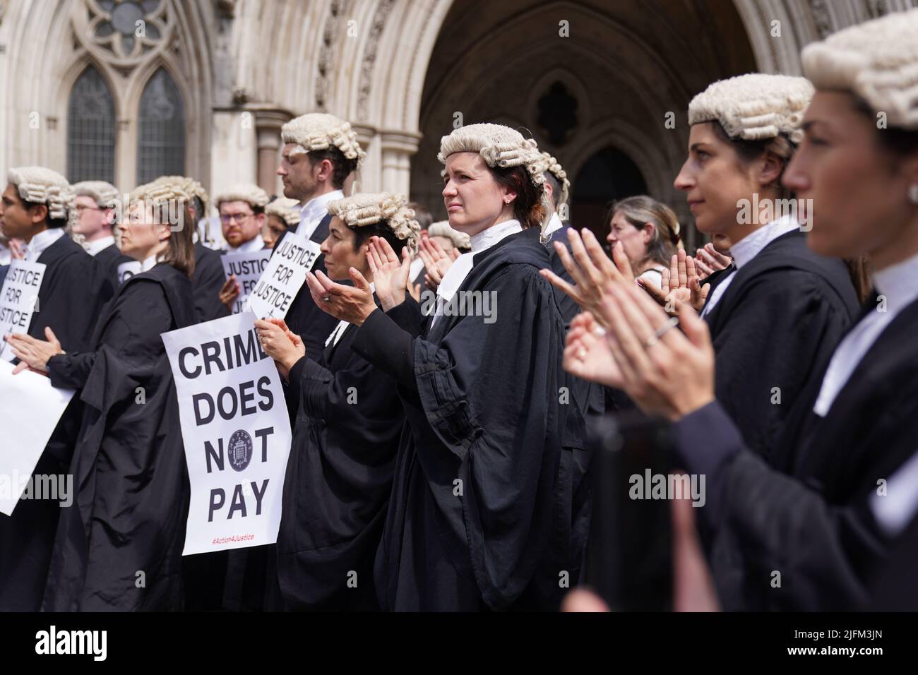 Criminal defence barristers gather outside the Royal Courts of Justice in London to support the ongoing Criminal Bar Association (CBA) action over Government set fees for legal aid advocacy work. Picture date: Monday July 4, 2022. Stock Photo