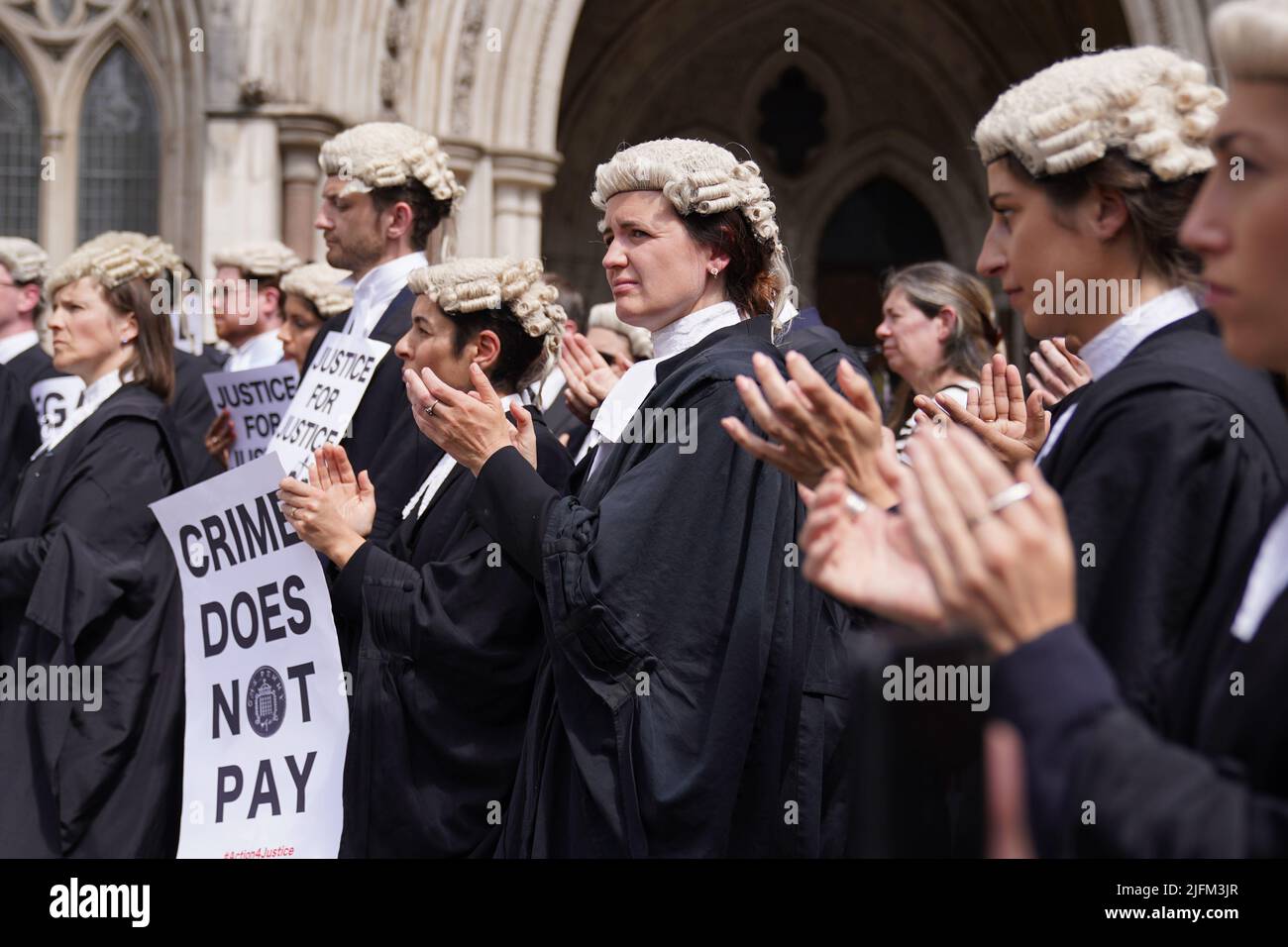 Criminal defence barristers gather outside the Royal Courts of Justice in London to support the ongoing Criminal Bar Association (CBA) action over Government set fees for legal aid advocacy work. Picture date: Monday July 4, 2022. Stock Photo