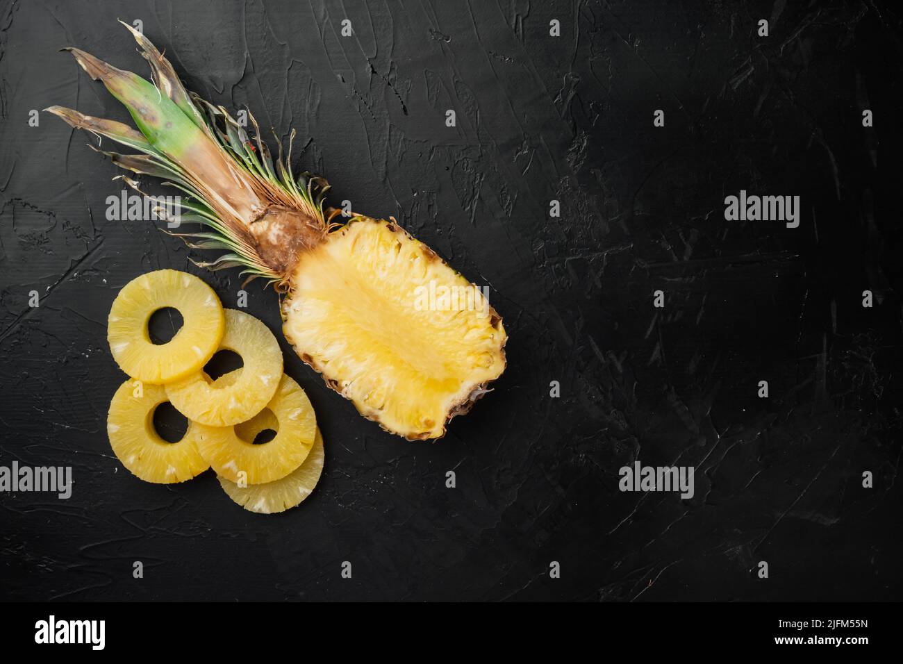 Pineapple slice, on black dark stone table background, top view flat lay, with copy space for text Stock Photo