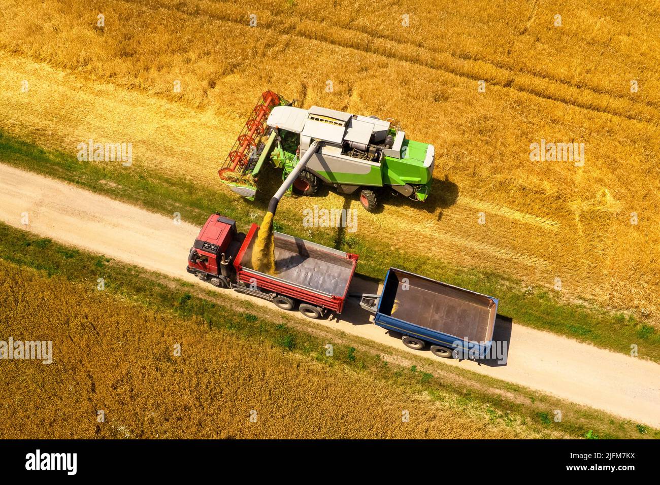 Wheat shortage, high trading prices, stockpiling. Aerial view of a combine harvester at work during harvest time. Agricultural background. Stock Photo