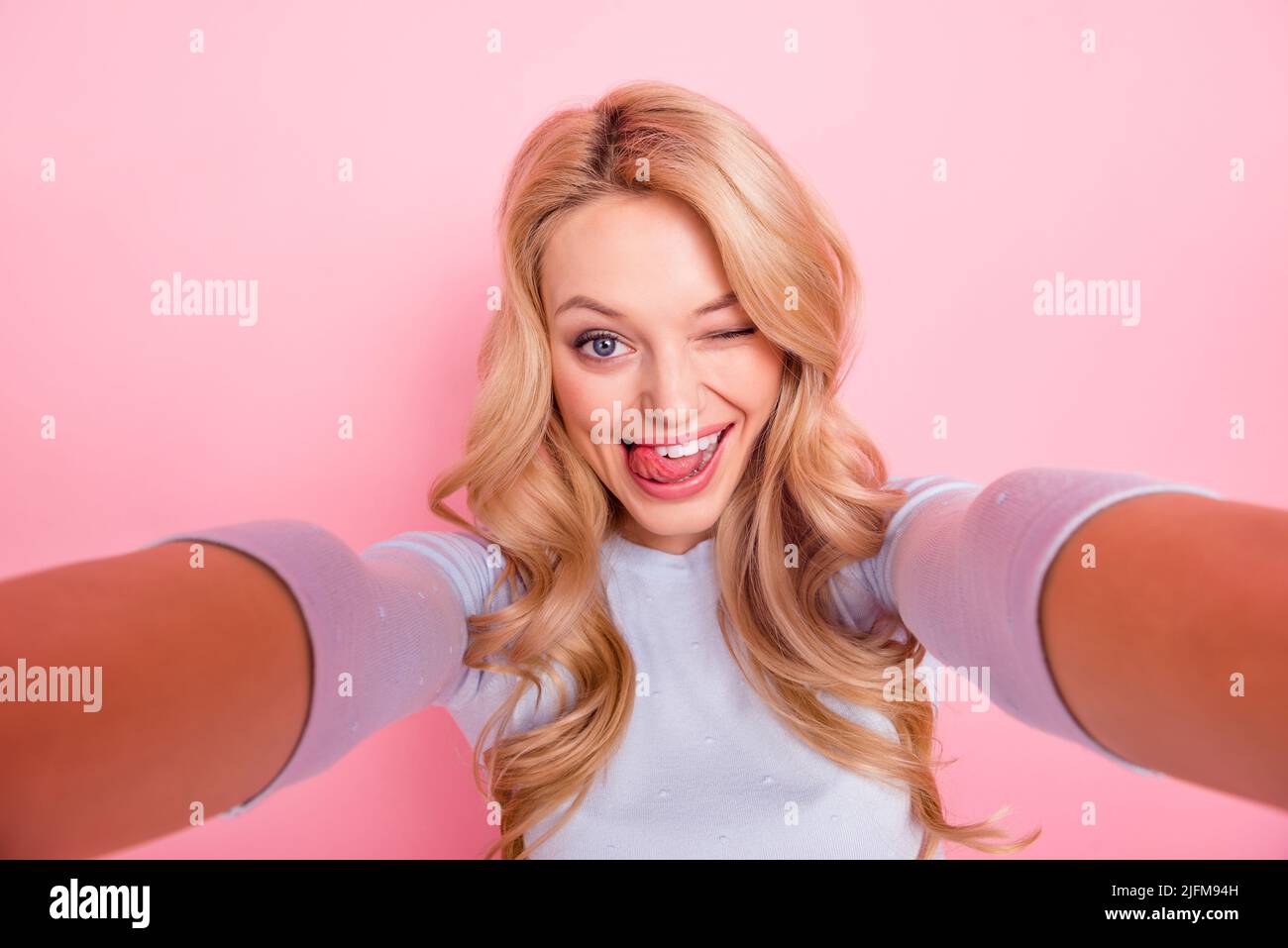Portrait of gorgeous cheerful lady take selfie tongue lick teeth isolated on pink color background Stock Photo
