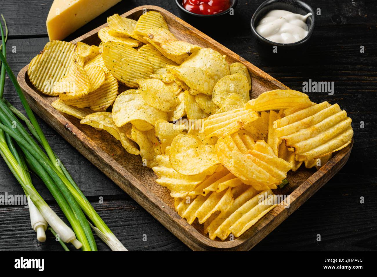 Variation different potato chips on black wooden table background Stock ...