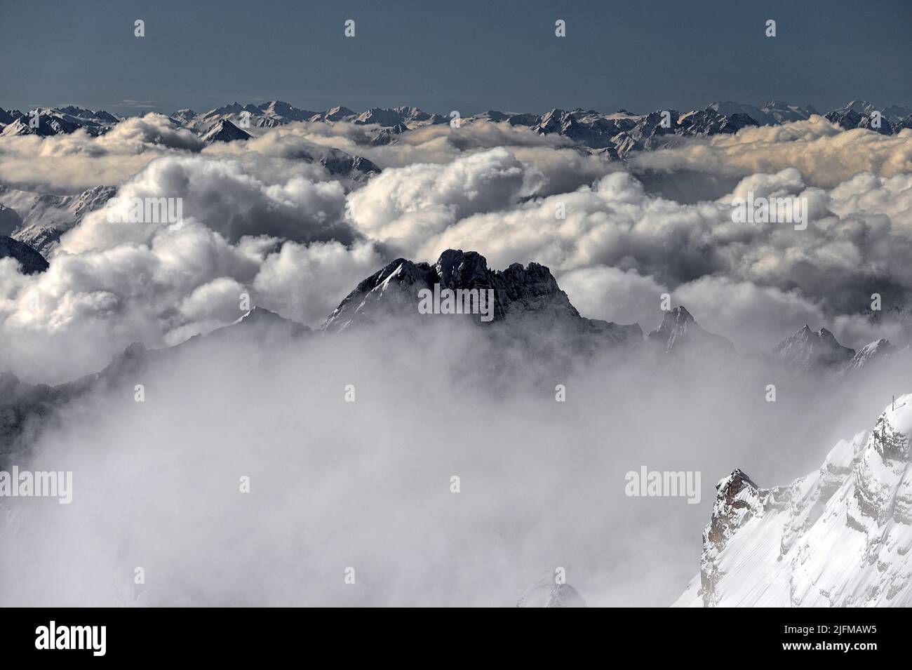 Die Zugspitze liegt meistens über den Wolken. Hier ragt nur eine Bergspitze aus der dichten Wolkendecke. Stock Photo