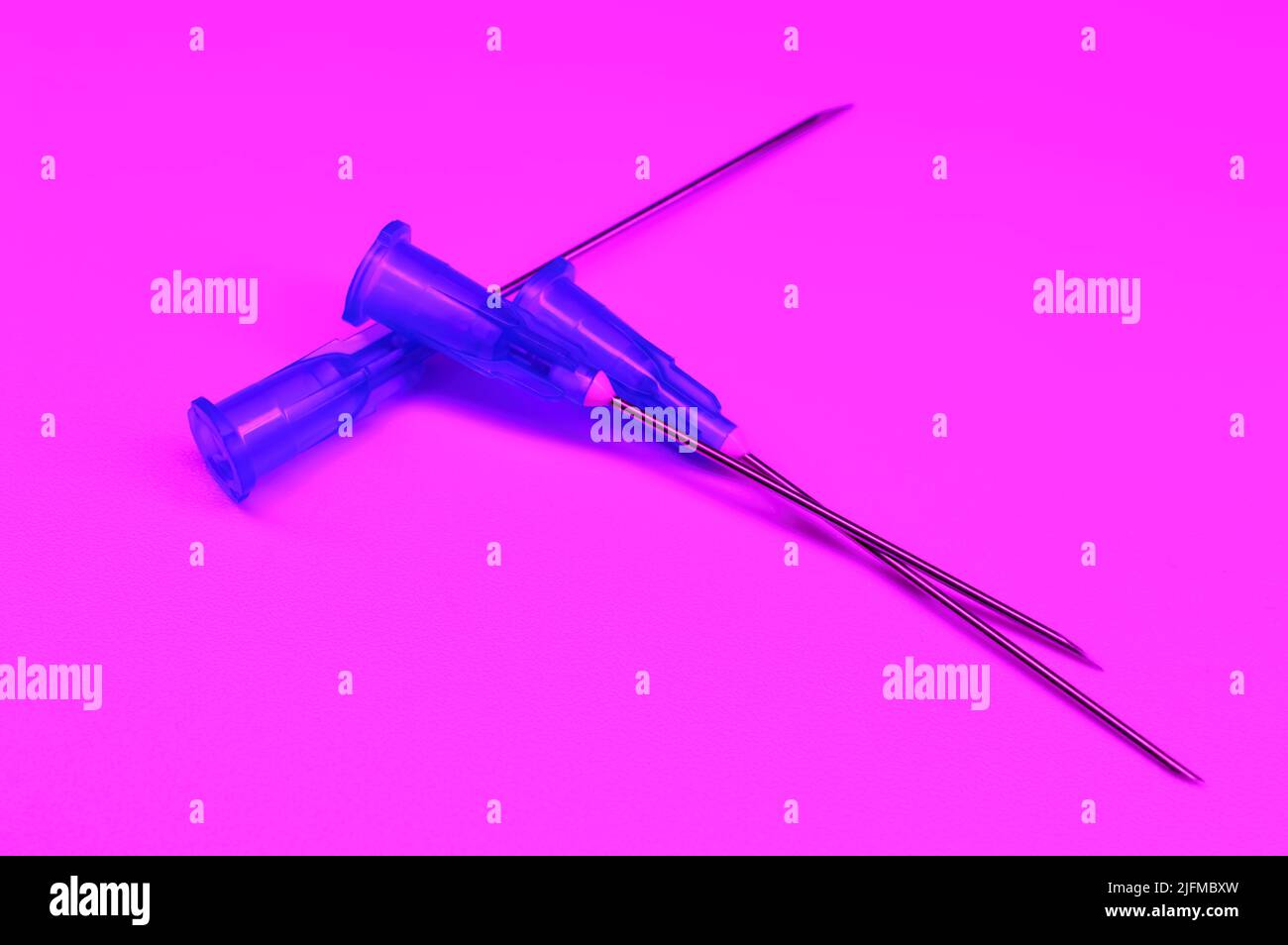 Medical syringe's needles compilation on a purple background. Social problems.  Drugs and medical treatment. Stock Photo