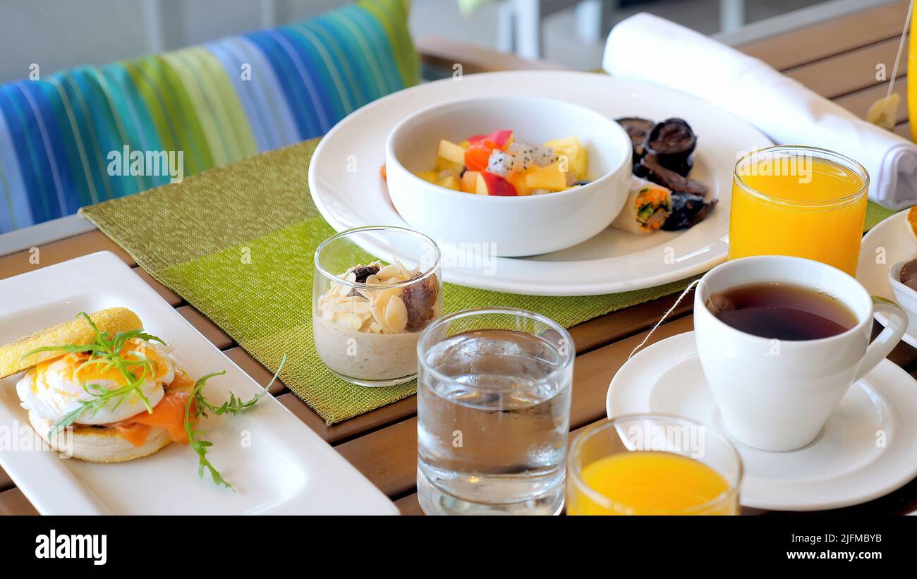 Hotel table with breakfast food. Served meal in modern tropical resort