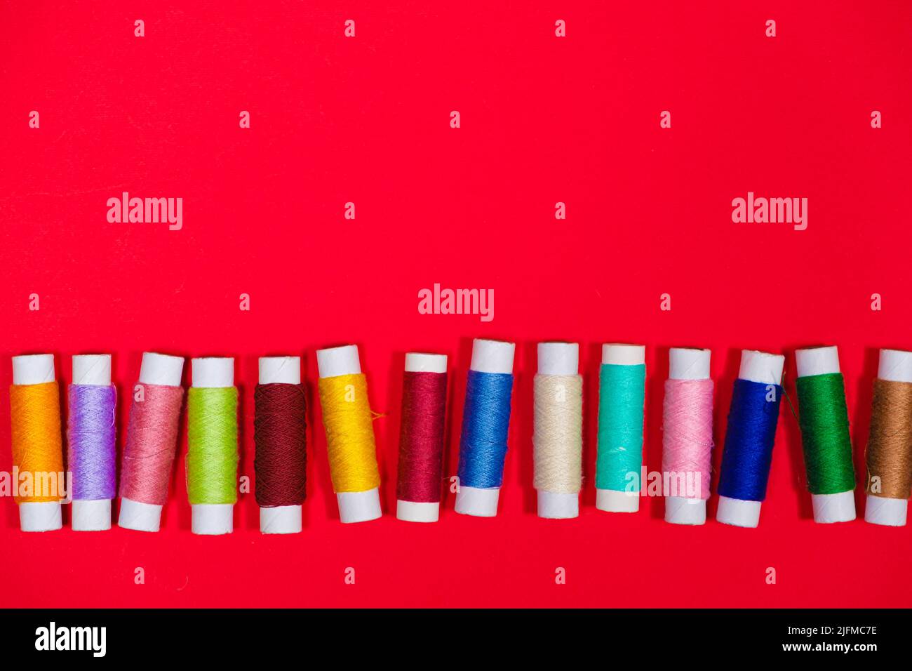 A set of multi-colored threads for sewing with an empty space for text ...