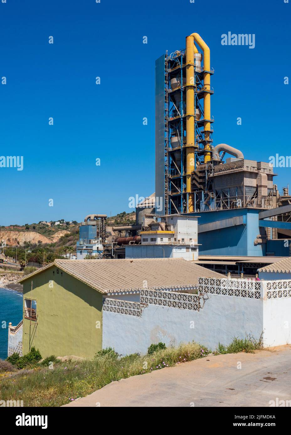 Cement factory in front of a village Stock Photo