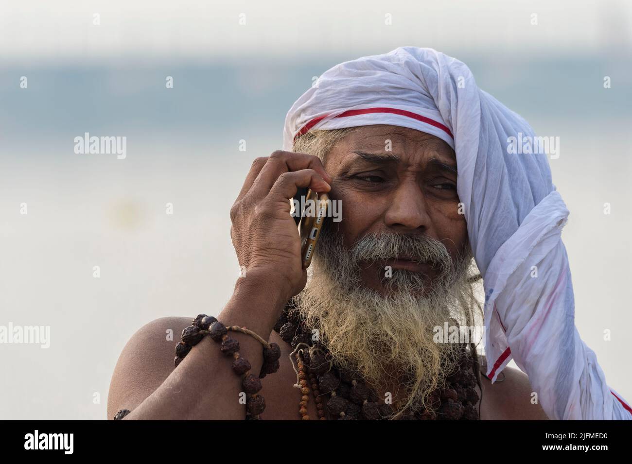 Rome Baba phoning with a cellular on Ganges riverbank, For Editorial Use Only, Allahabad Kumbh Mela, World’s largest religious gathering, Uttar Prades Stock Photo