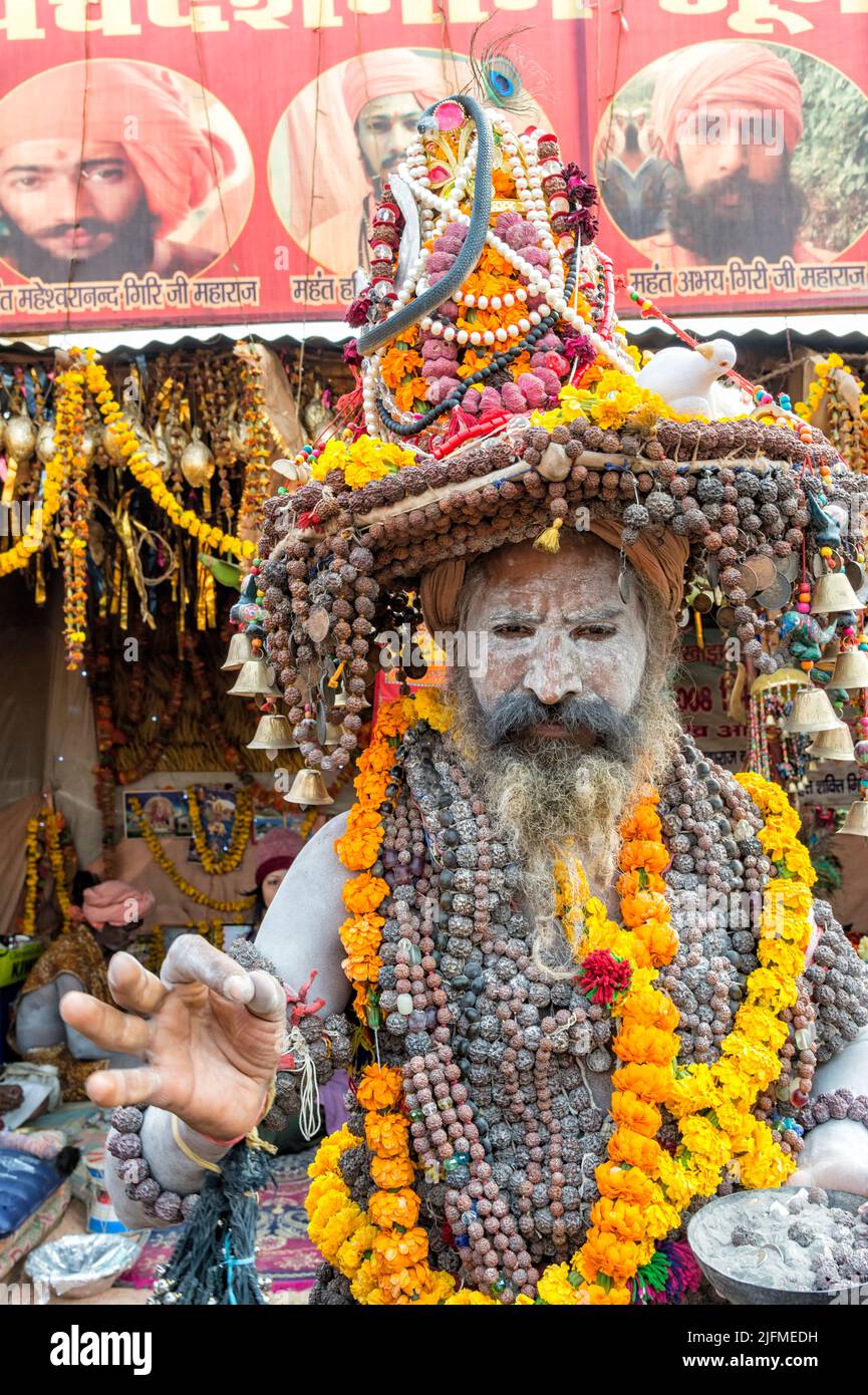 White ash covered sadhu with a hat decorated with Marigold garland necklaces and pearls, For editorial use only, Allahabad Kumbh Mela, World’s largest Stock Photo